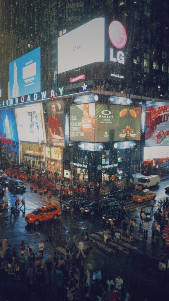 Huge televisions showing displayed advertising in a crowded area